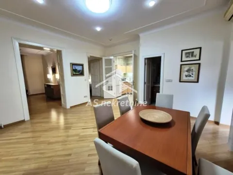 Dining area with a wooden table and chairs in a spacious apartment. - image 4