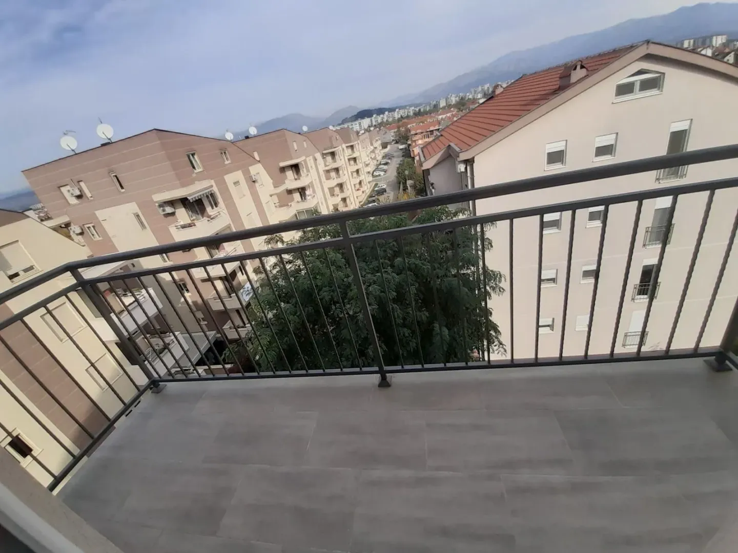 View from the tiled balcony onto the surrounding buildings and neighborhood.