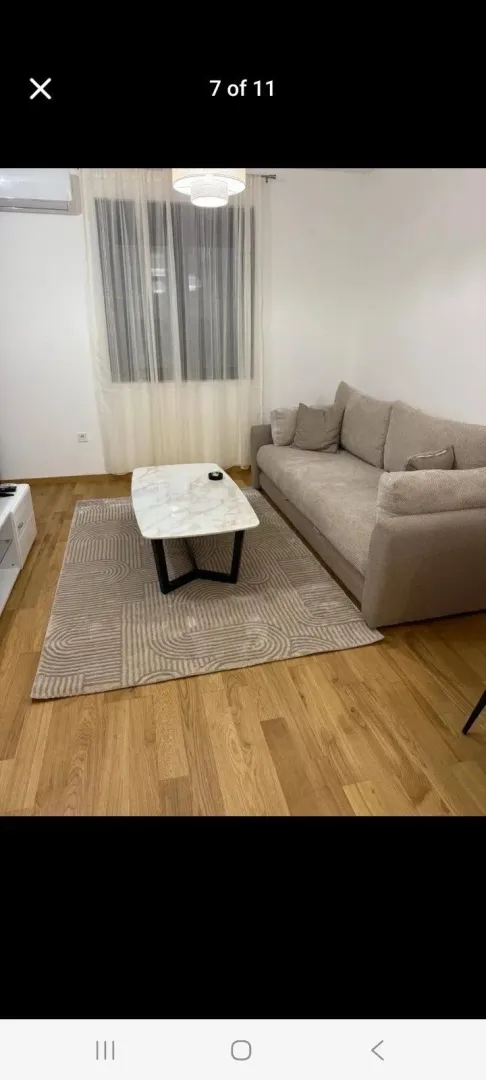 Dnevna soba sa garniturom, stočićem i tepihom.