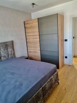 Nameštena spavaća soba sa bračnim krevetom i velikim ormanom. - image 5