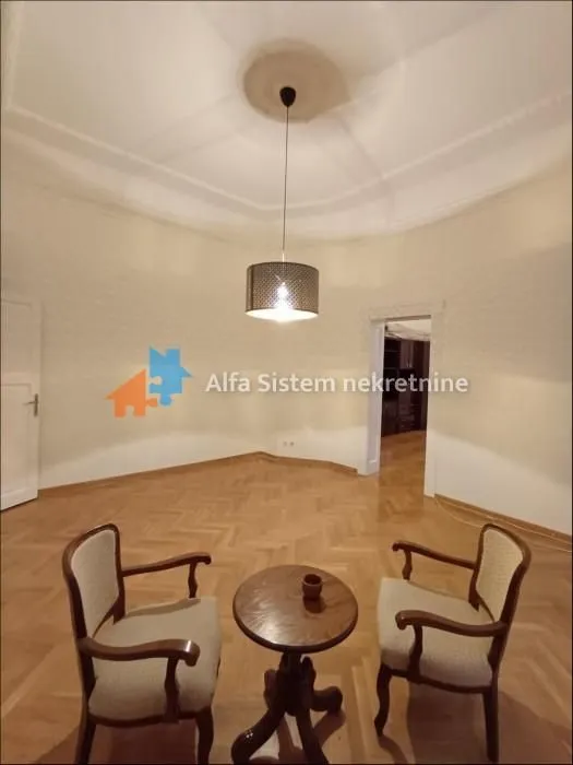 Living room with parquet flooring and seating set.