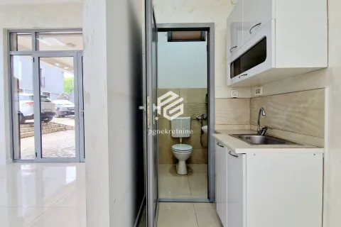 Smaller kitchen with a sink and white cabinetry, with a view of the bathroom and the entrance door. - image 3