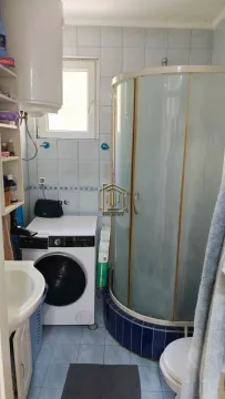 Smaller bathroom with a shower cabin and a washing machine. - image 6