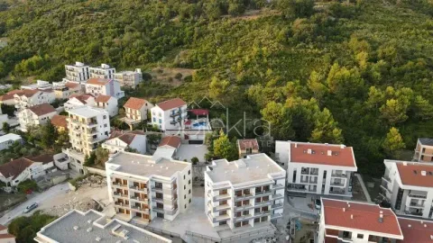 Pogled iz vazduha na stambeni kompleks sa više zgrada i okolnim zelenilom. - image 7