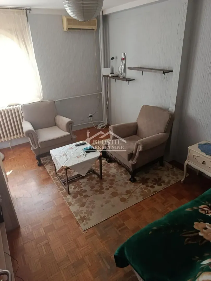 Living room with two armchairs, a coffee table, and parquet flooring.