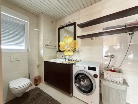Brightly equipped bathroom with a sink, toilet, and washing machine. - image 15