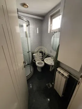 Small bathroom with a shower cabin, toilet, and sink. - image 15
