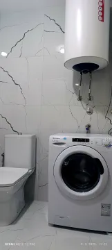 Modernly equipped bathroom with a washing machine and water heater. - image 2