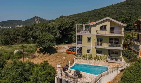 Pogled iz vazduha na višespratnu kuću sa bazenom i dvorištem okruženom zelenilom. - image 13