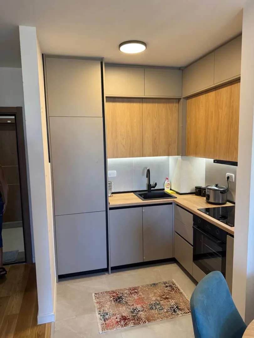Modern kitchen with wooden cabinetry and built-in appliances.