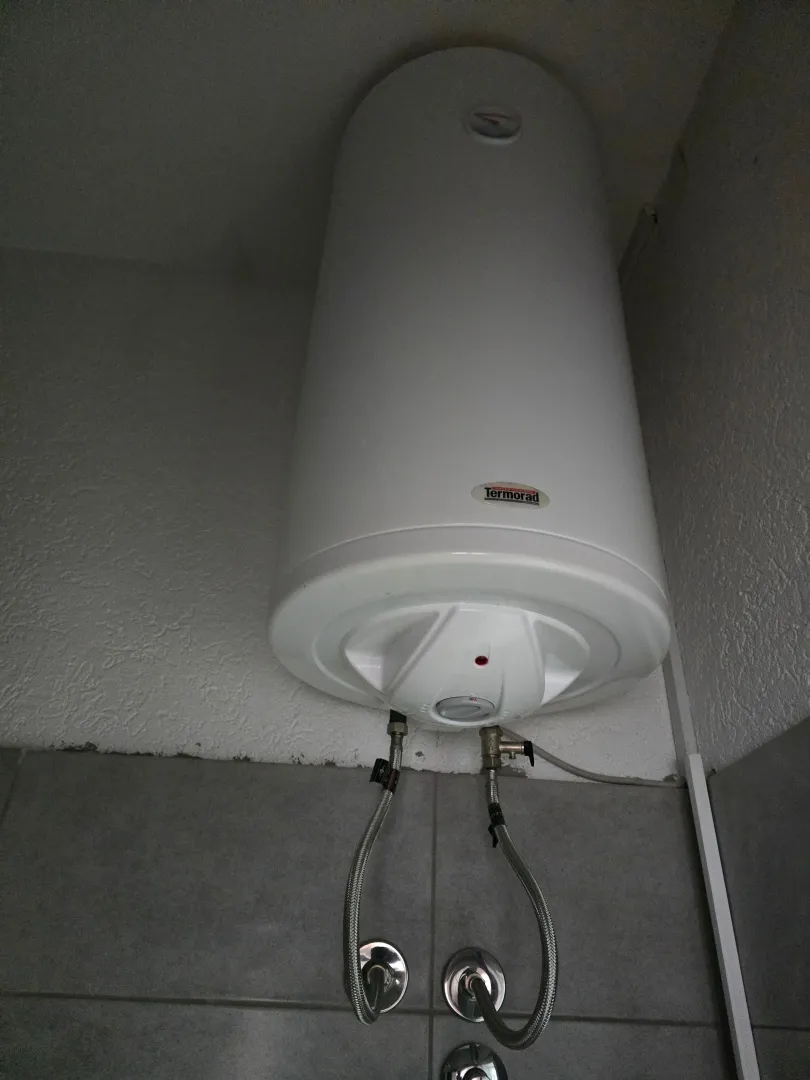 Električni bojler montiran na zid u kupatilu.
