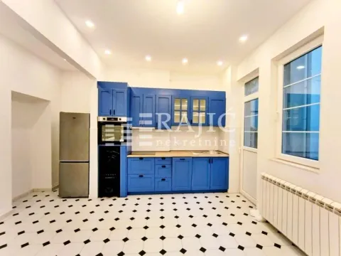 Spacious kitchen with blue cabinetry and black-and-white ceramic floor tiles. - image 2