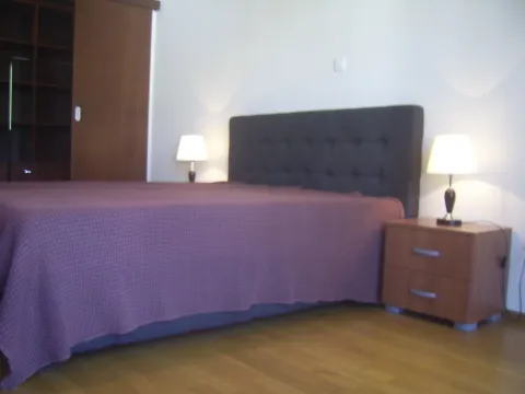 Jednostavno namještena spavaća soba sa bračnim krevetom i noćnim ormarićima. - image 13