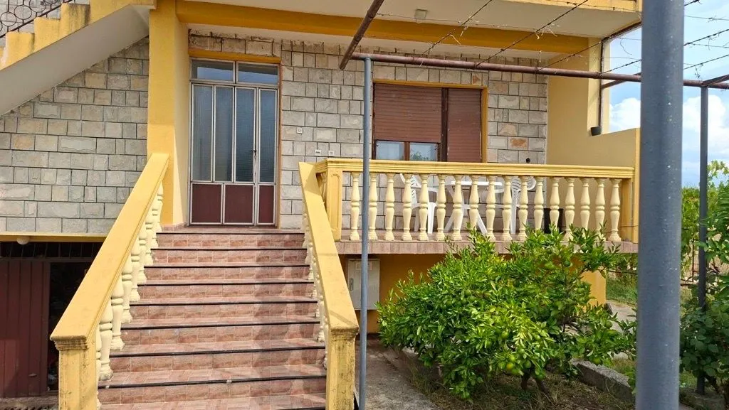 Exterior view of the house with stairs and a terrace.