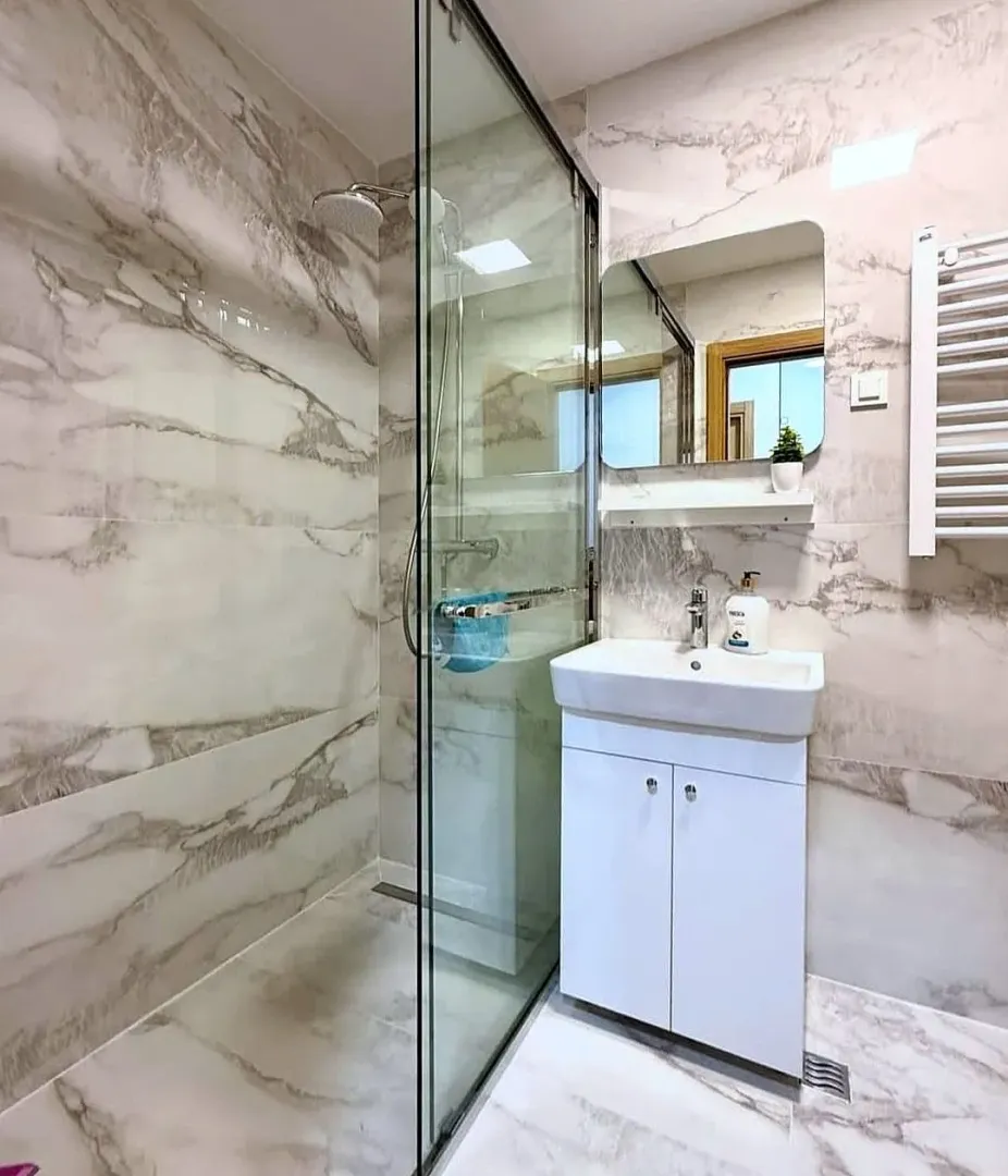 Modern bathroom featuring a glass-enclosed shower and a vanity sink.
