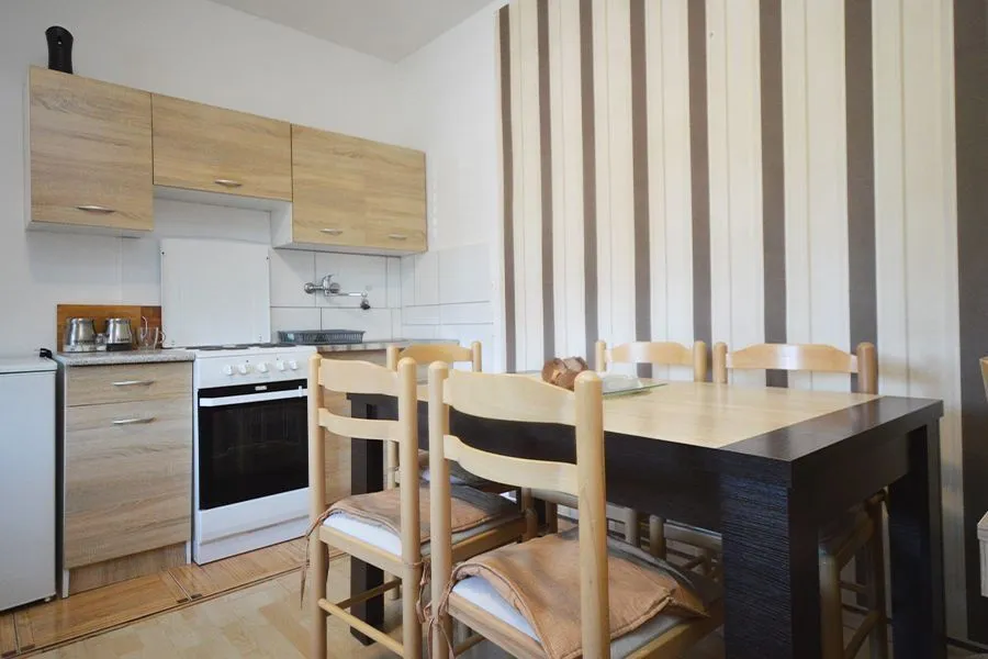 Smaller kitchen with a dining table and wooden cabinets.