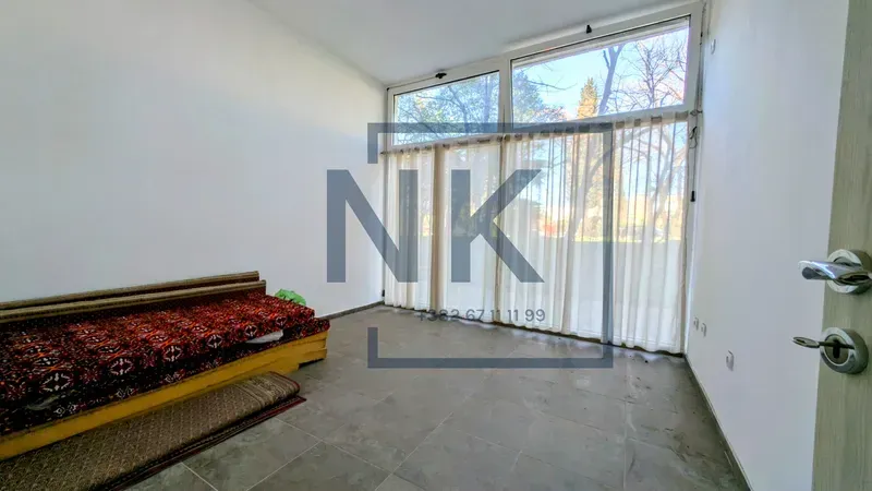 Living room with large windows and a sofa.