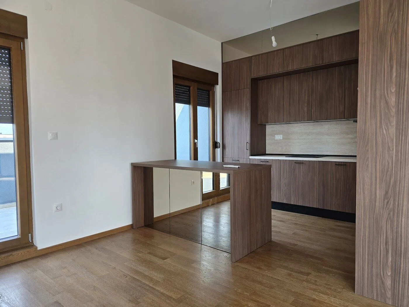 Modern kitchen with dark wood cabinetry and a dining table.