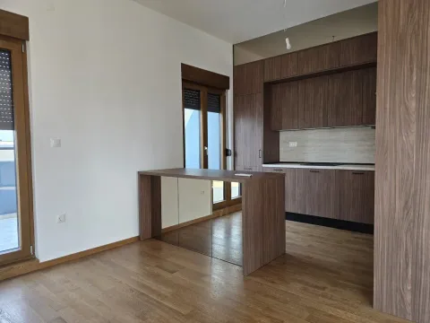 Modern kitchen with dark wood cabinetry and a dining table. - image 12