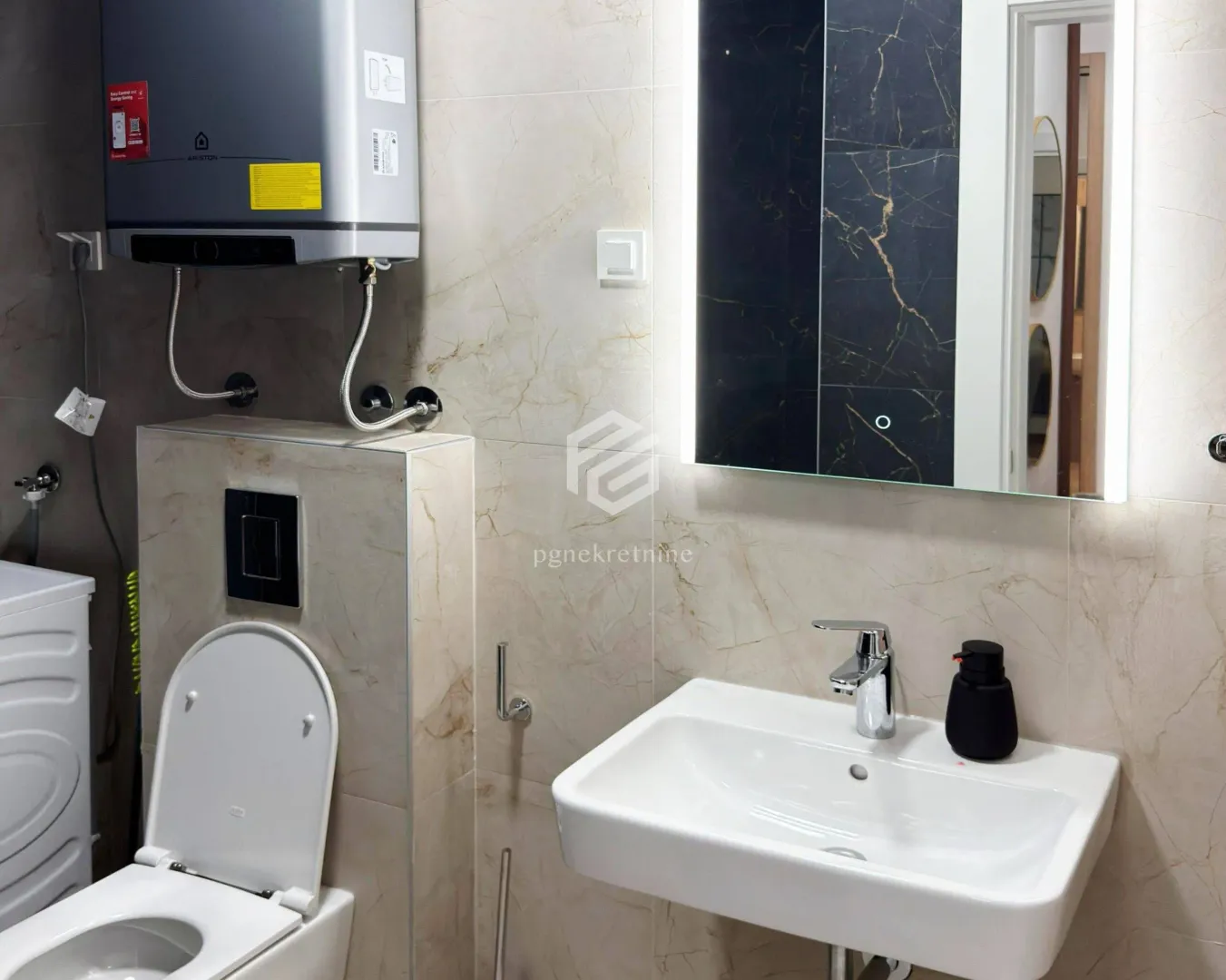 Moderne kupatilo sa lavaboom, wc šoljom i ugrađenim bojlerom.