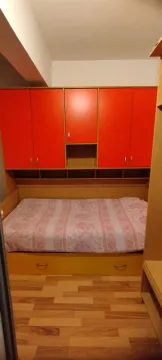Manja spavaća soba sa krevetom i ugradnim ormarom u narandžastoj boji. - image 4