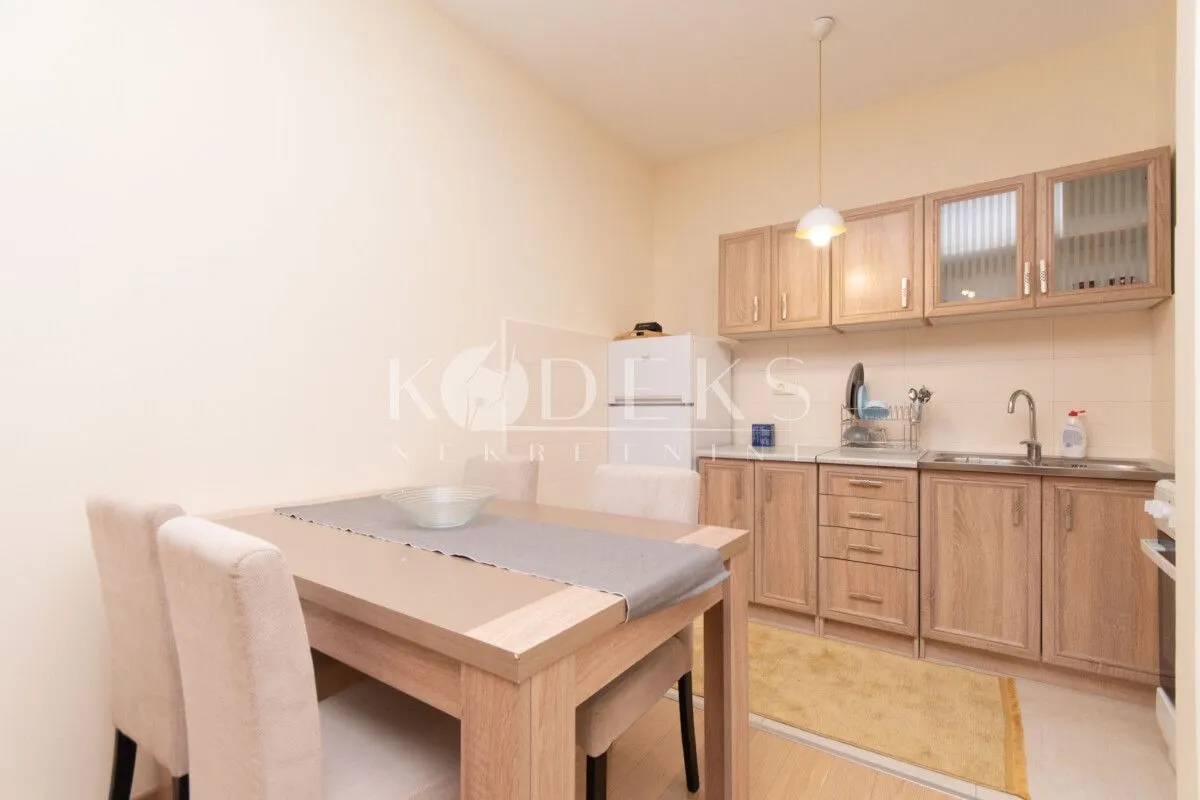 Small kitchen with a dining table and wooden cabinets.