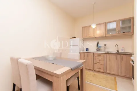 Small kitchen with a dining table and wooden cabinets. - image 4