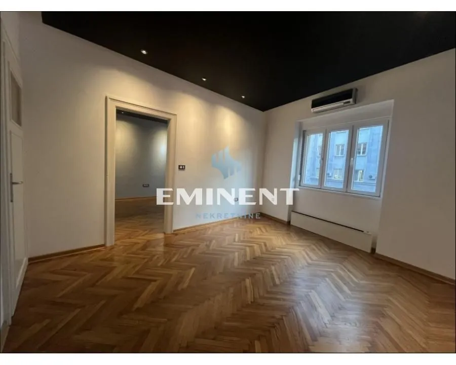 Empty room with parquet flooring and a black ceiling.