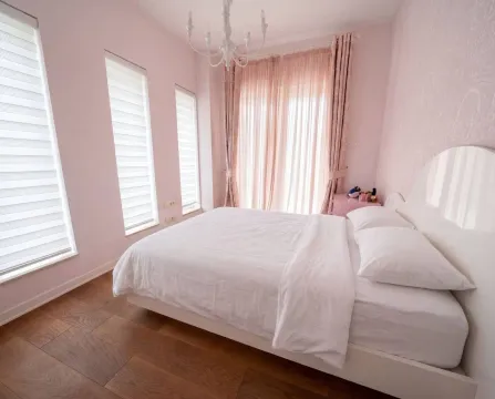 Bright bedroom with a double bed, pink details, and windows. - image 10