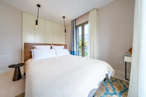 Modern bedroom with a double bed, built-in wardrobe, and balcony access. - image 11