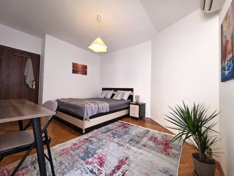 Furnished bedroom with a double bed, rug, and table. - image 16
