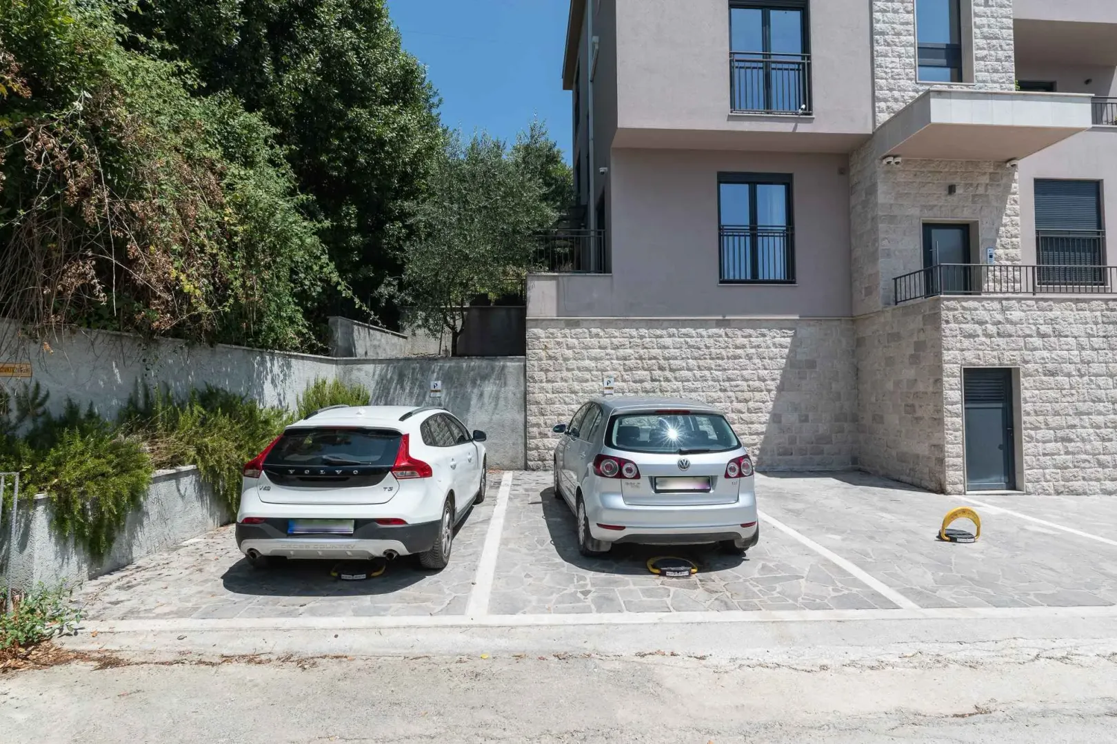 Spoljni dio zgrade sa označenim parking mjestima.