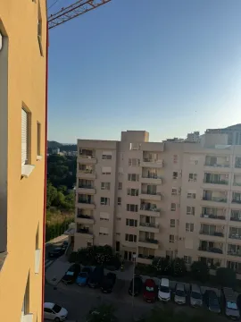 View from the window overlooking surrounding buildings and parking lot. - image 8