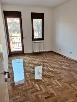 Prazna soba sa parketom, prozorom i balkonskim vratima. - image 7