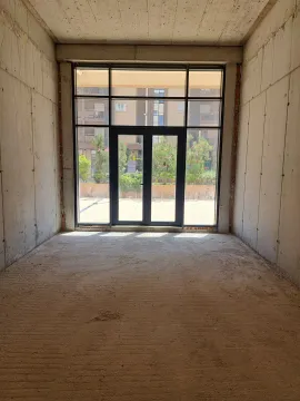 Unfinished commercial space with glass entrance doors and a courtyard view. - image 6