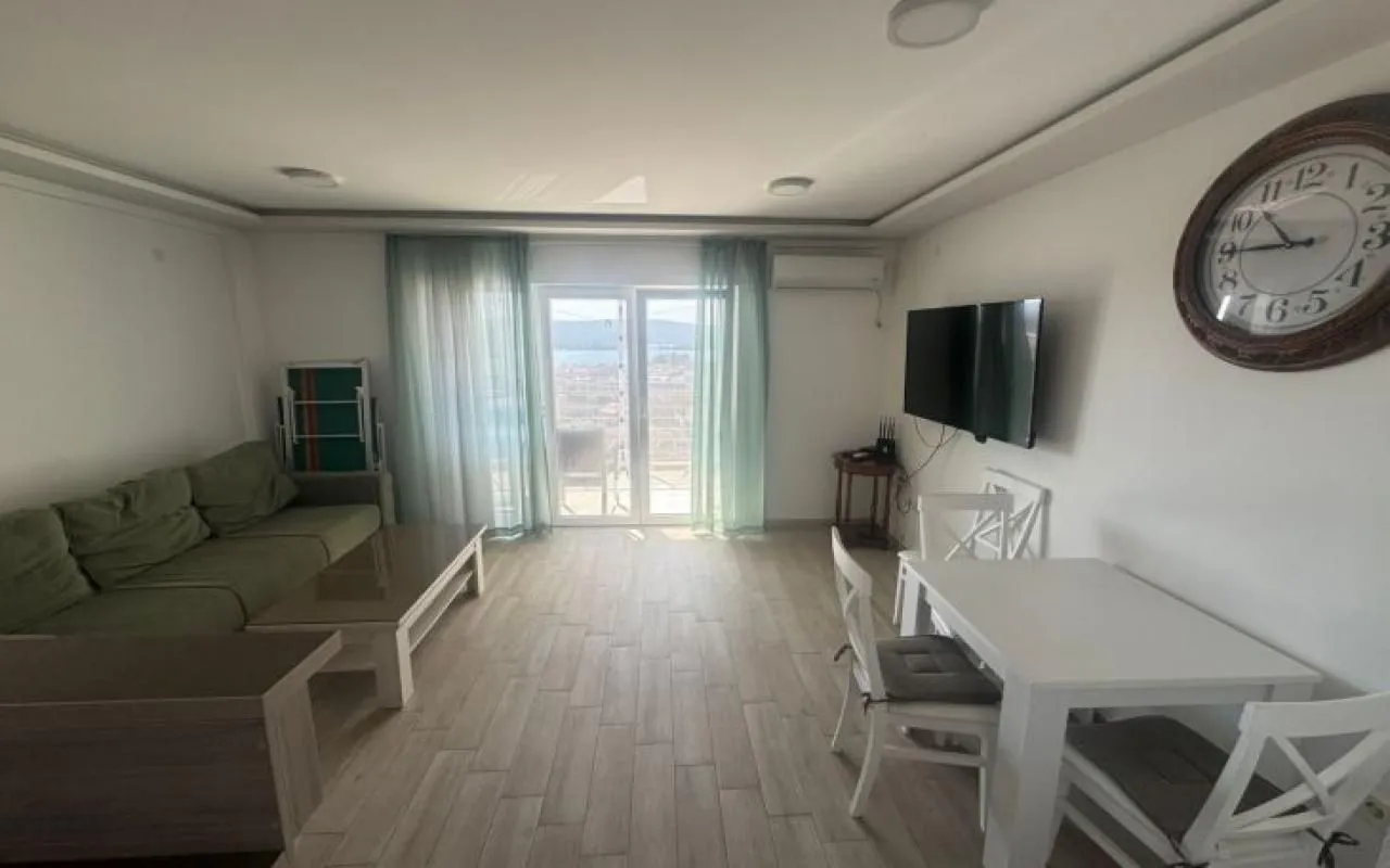 Dnevni boravak sa garniturom, trpezarijskim stolom i izlazom na terasu.