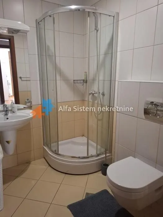 Bathroom with a shower cabin, washbasin, and toilet.