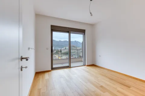 Empty room with wooden flooring and balcony doors. - image 10