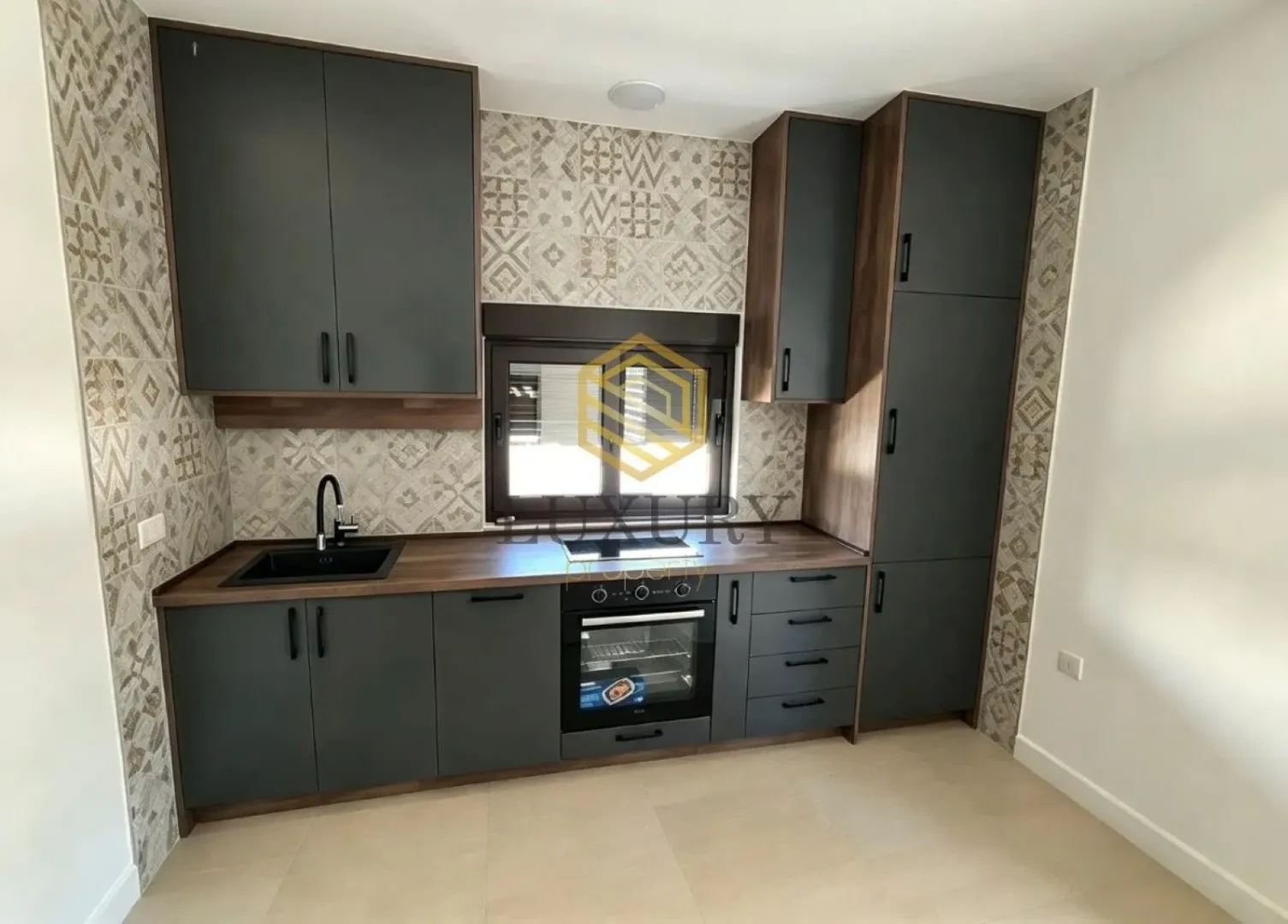 Modern kitchen with dark cabinets and built-in appliances.
