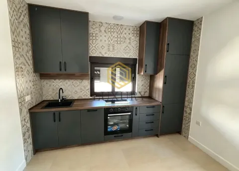 Modern kitchen with dark cabinets and built-in appliances. - image 7