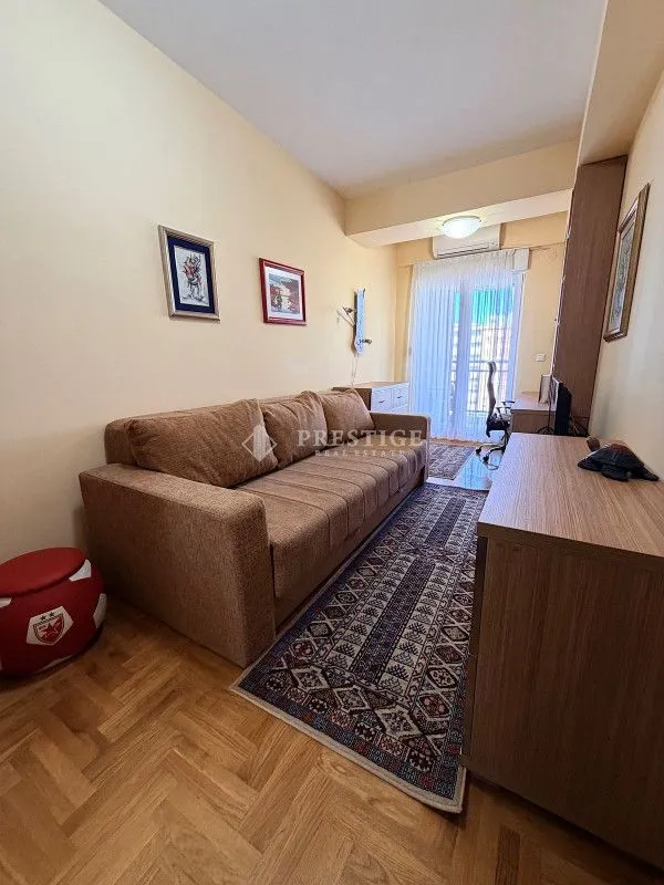 Living room with sofa, parquet flooring, and access to the terrace.