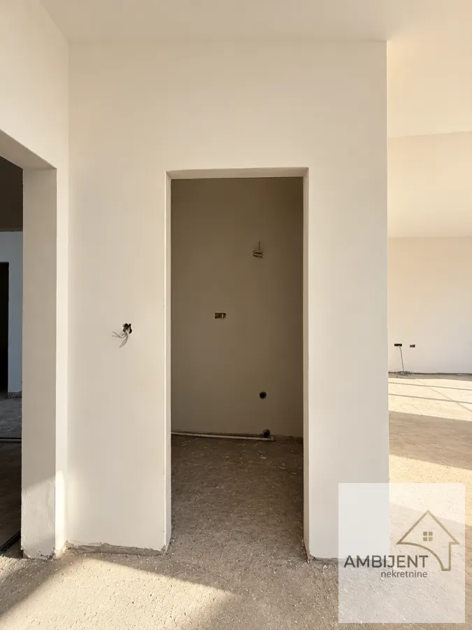 Empty room under construction with an open doorway and white-painted walls.