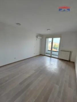 Prazna svetla soba sa drvenim podom i izlazom na terasu. - image 4