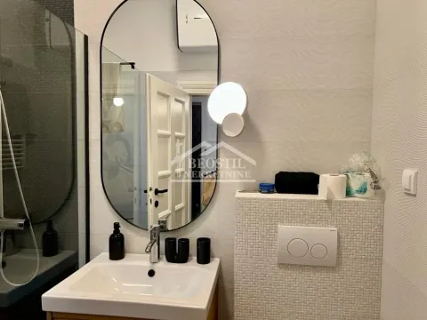 Modernly equipped bathroom with a sink, mirror, and walk-in shower. - image 7