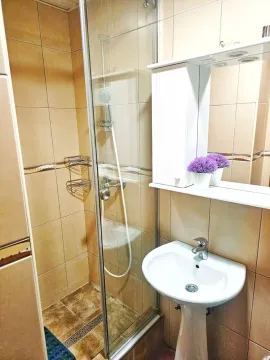 Smaller bathroom with a shower cabin, washbasin, and mirrored cabinet. - image 20