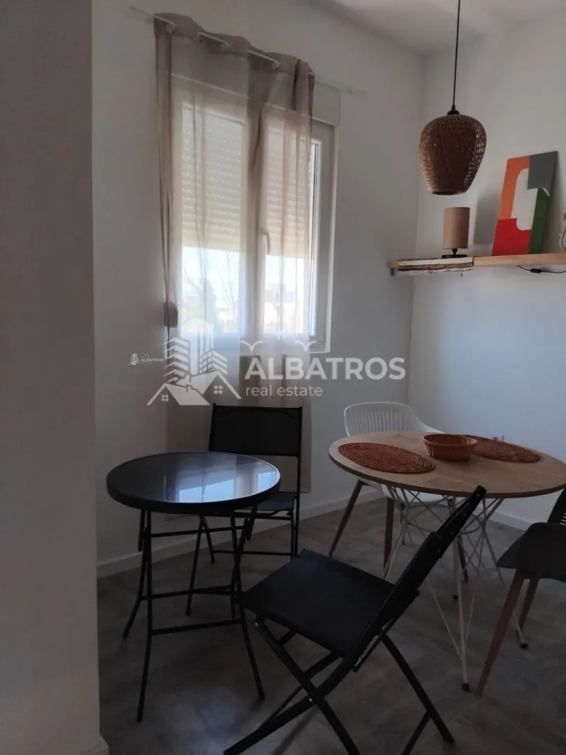 Small dining area with a table and chairs by the window.