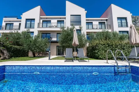 View of the exterior of the building with a swimming pool and landscaped yard. - image 8