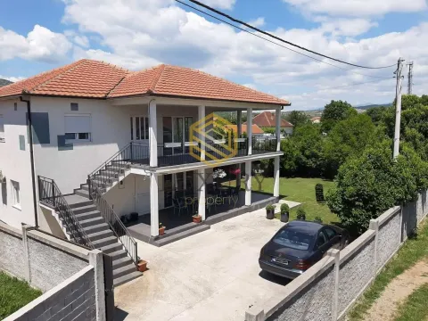 Aerial view of a two-story house with a yard and parked car. - image 2