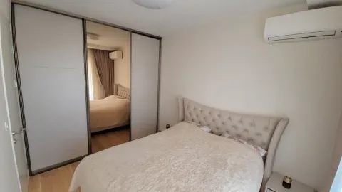 Furnished bedroom with a double bed and a large built-in wardrobe with a mirror. - image 8