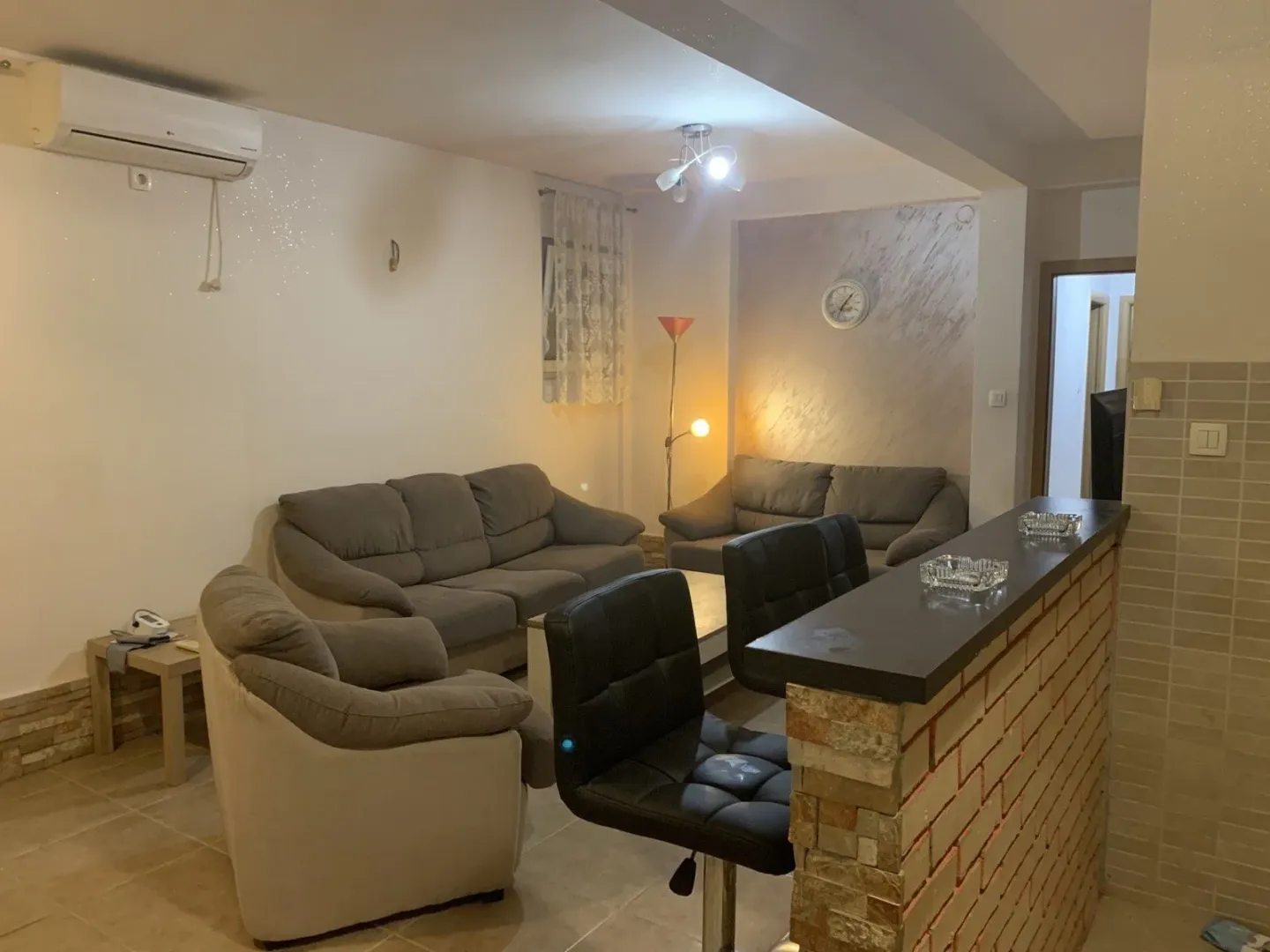 Bright living room with a sofa set and a bar counter.